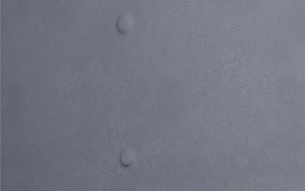 Close-up of a nail pop pushing through drywall