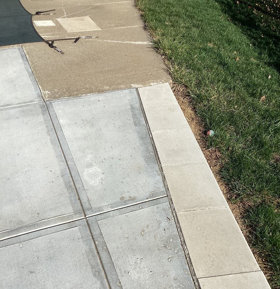 Completed concrete flatwork installation showing new concrete pavement sections adjacent to grass and existing sidewalk.