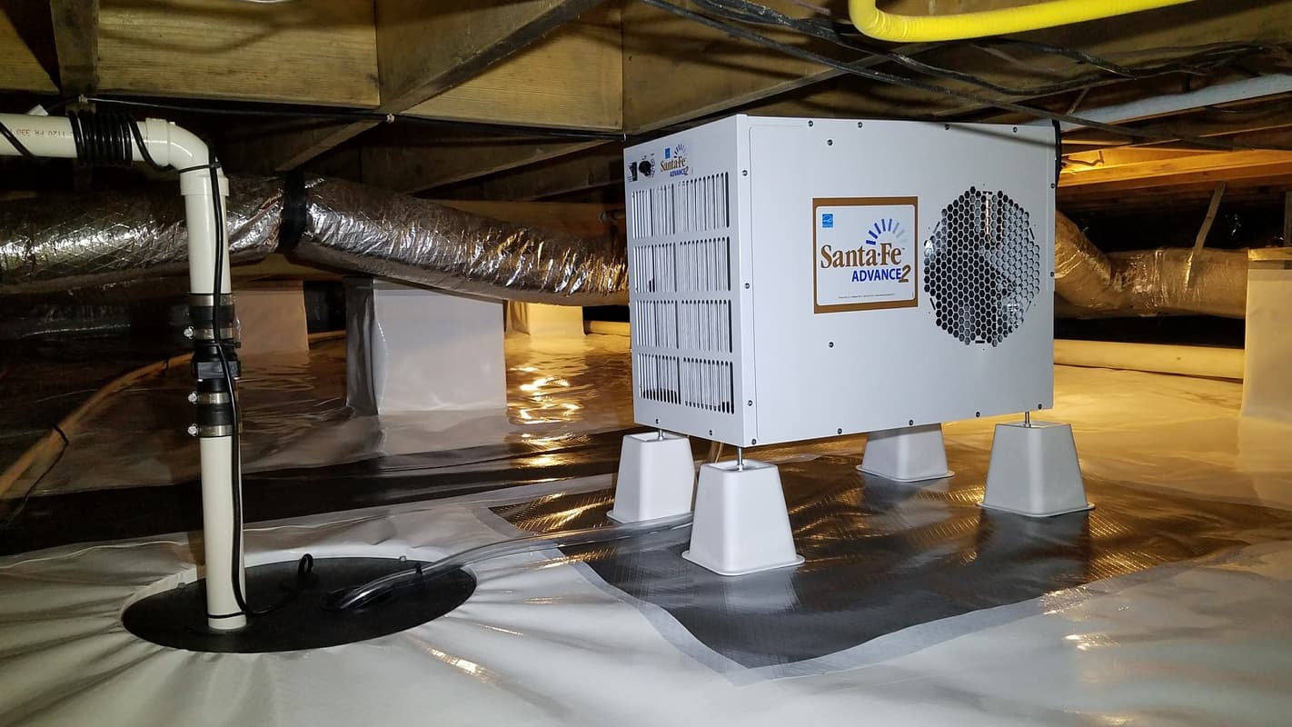 Santa Fe Advance dehumidifier installed in a clean crawl space with white vapor barrier and sump pump