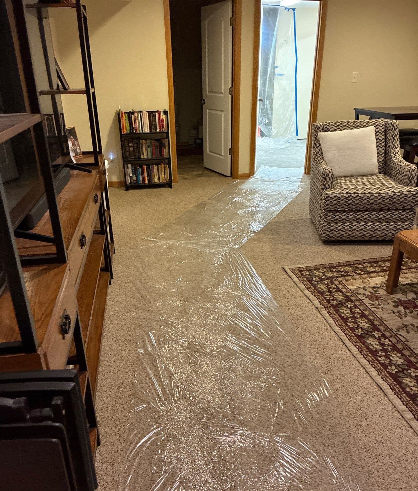 Epp Foundation Repair protecting homeowner's carpet with plastic sheeting during crawl space repair in Lincoln, Nebraska.