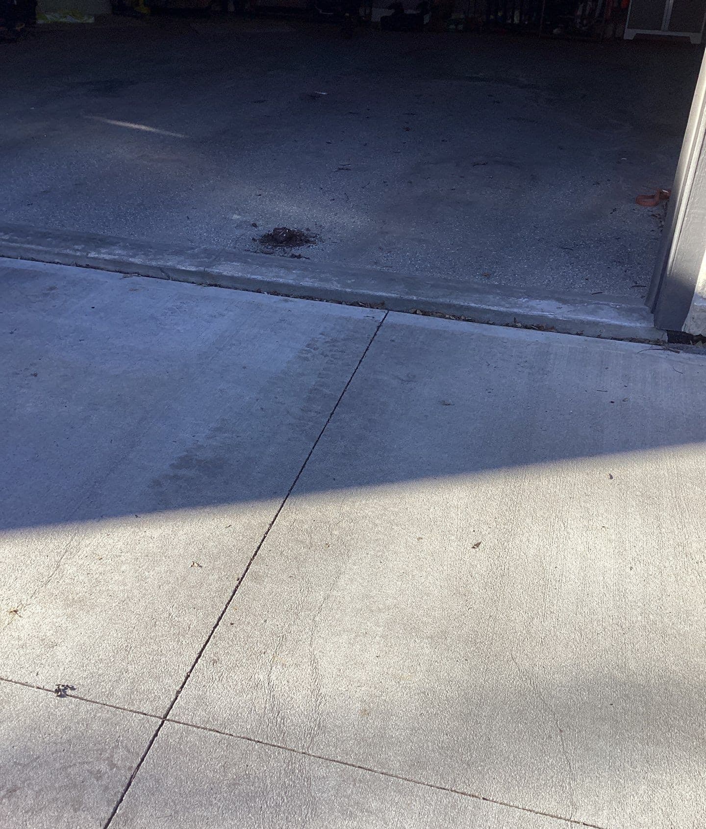 Epp Foundation Repair inspecting cracked concrete and shadow on a residential driveway in Omaha, Nebraska