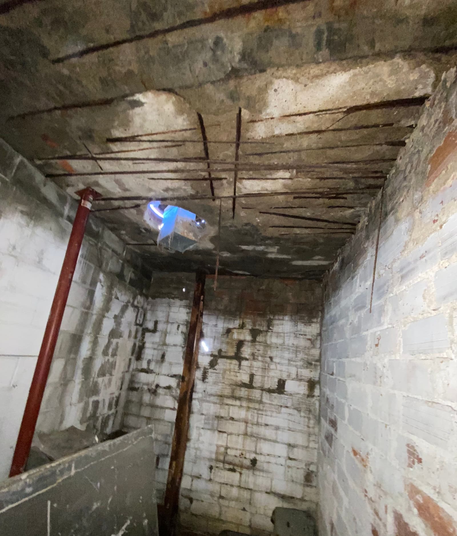 Epp Foundation Repair inspecting concrete foundation upheaval with exposed rebar, spalling, and moisture issues in Lincoln, N