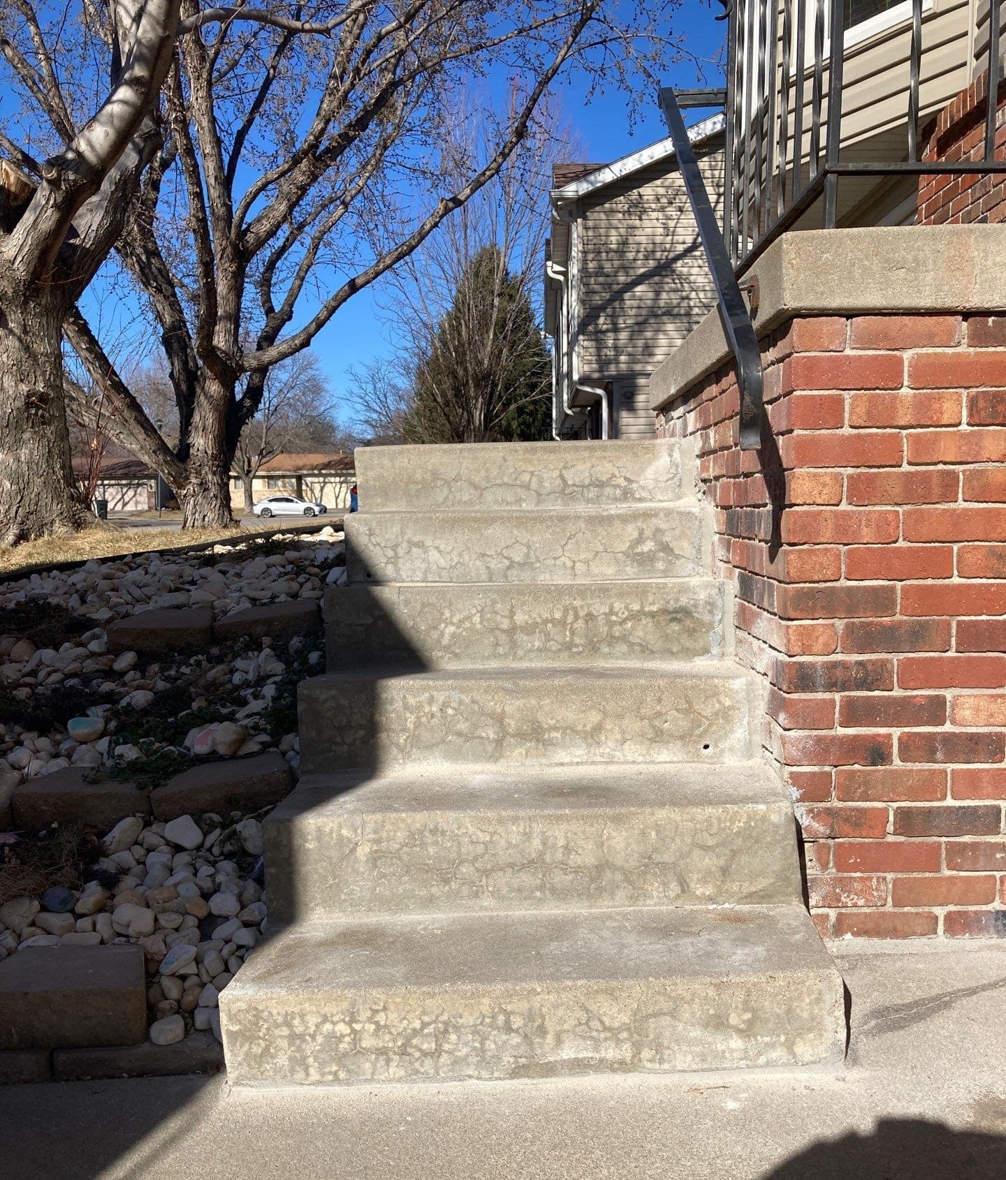 Early warning signs of pitting, flaking, and staining on exterior concrete on a Midwest home