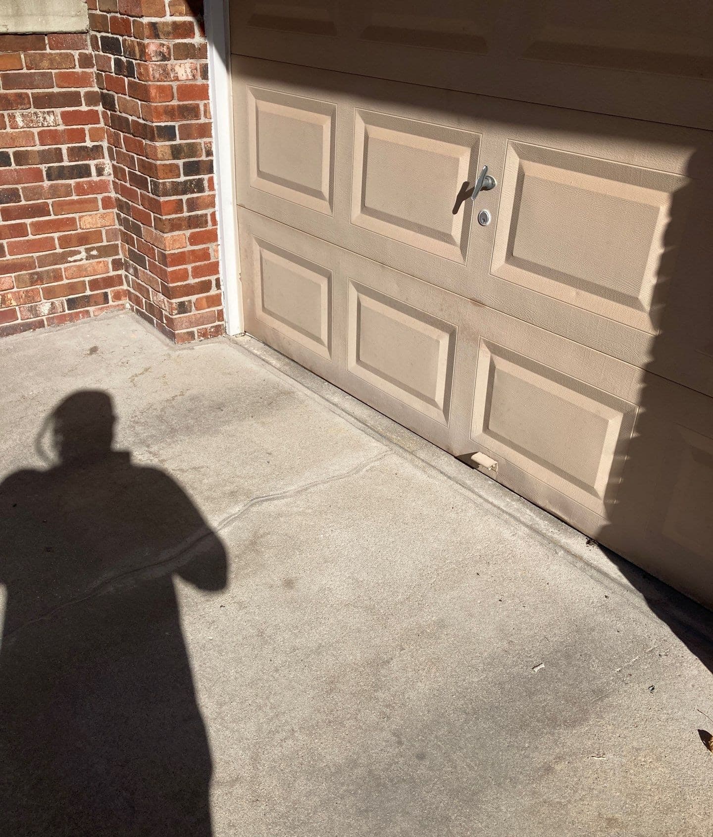 Epp Foundation Repair inspecting a cracked concrete garage floor and adjacent brick in Lincoln, Nebraska.