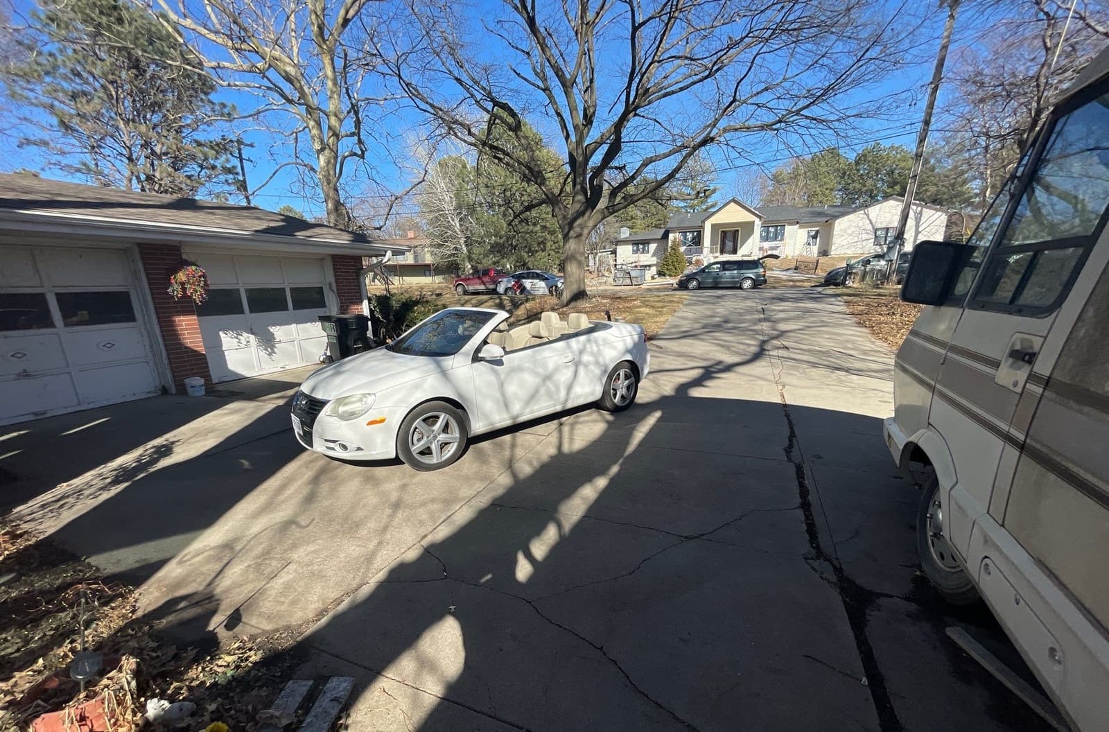 Epp Foundation Repair identifying cracks in concrete driveway in Lincoln, NE, visible next to a white car and a service van.