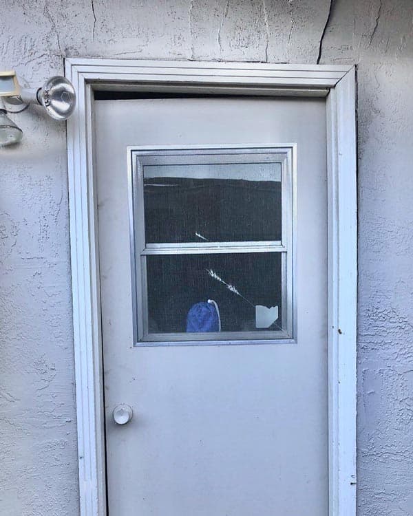 Epp Foundation Repair inspecting significant gaps around an exterior door frame and a severely cracked window.