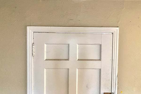 Epp Foundation Repair inspecting a diagonal crack above an interior door frame.
