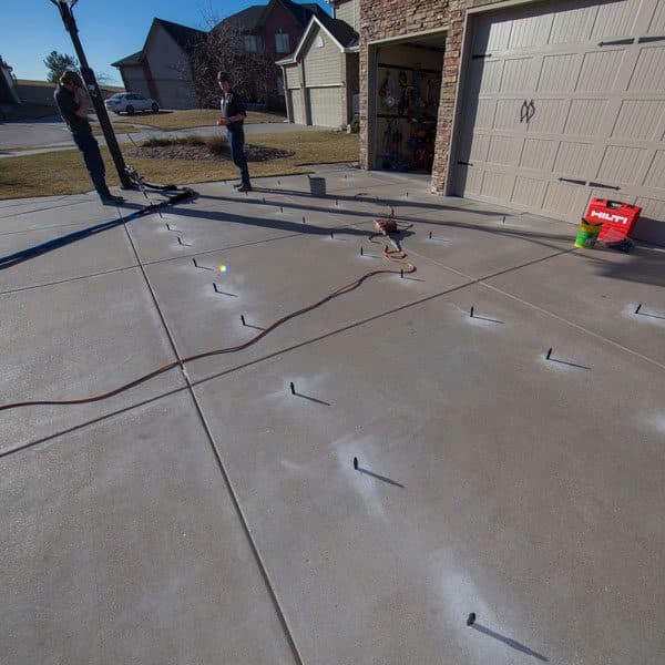 Epp Foundation Repair technicians preparing a concrete driveway for polyurethane foam injection