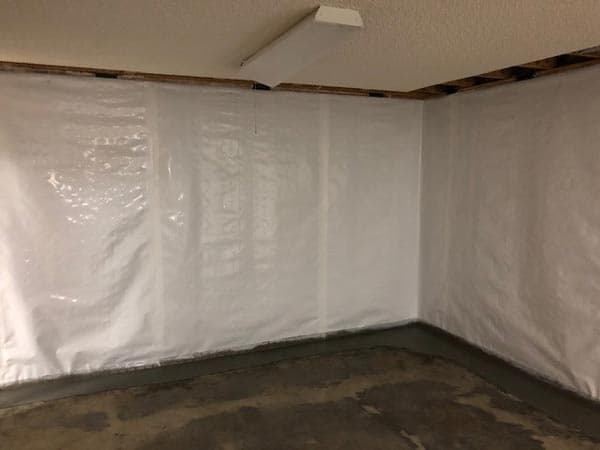 Epp Foundation Repair installing a vapor barrier on basement walls to prevent moisture and waterproof the interior.