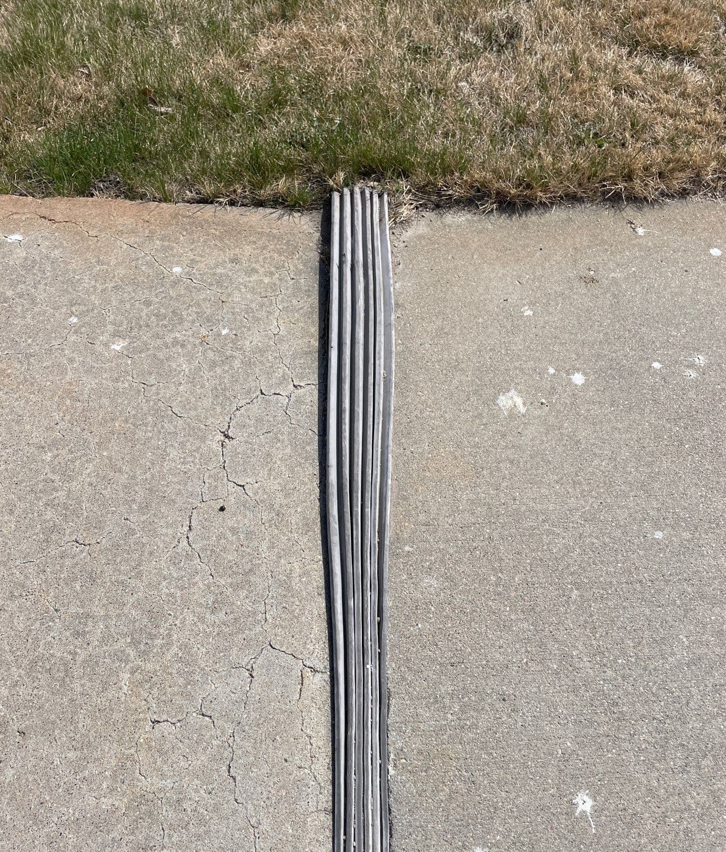 Epp Foundation Repair inspecting and sealing a cracking concrete expansion joint with filler, showing nearby cracks in Cozad,