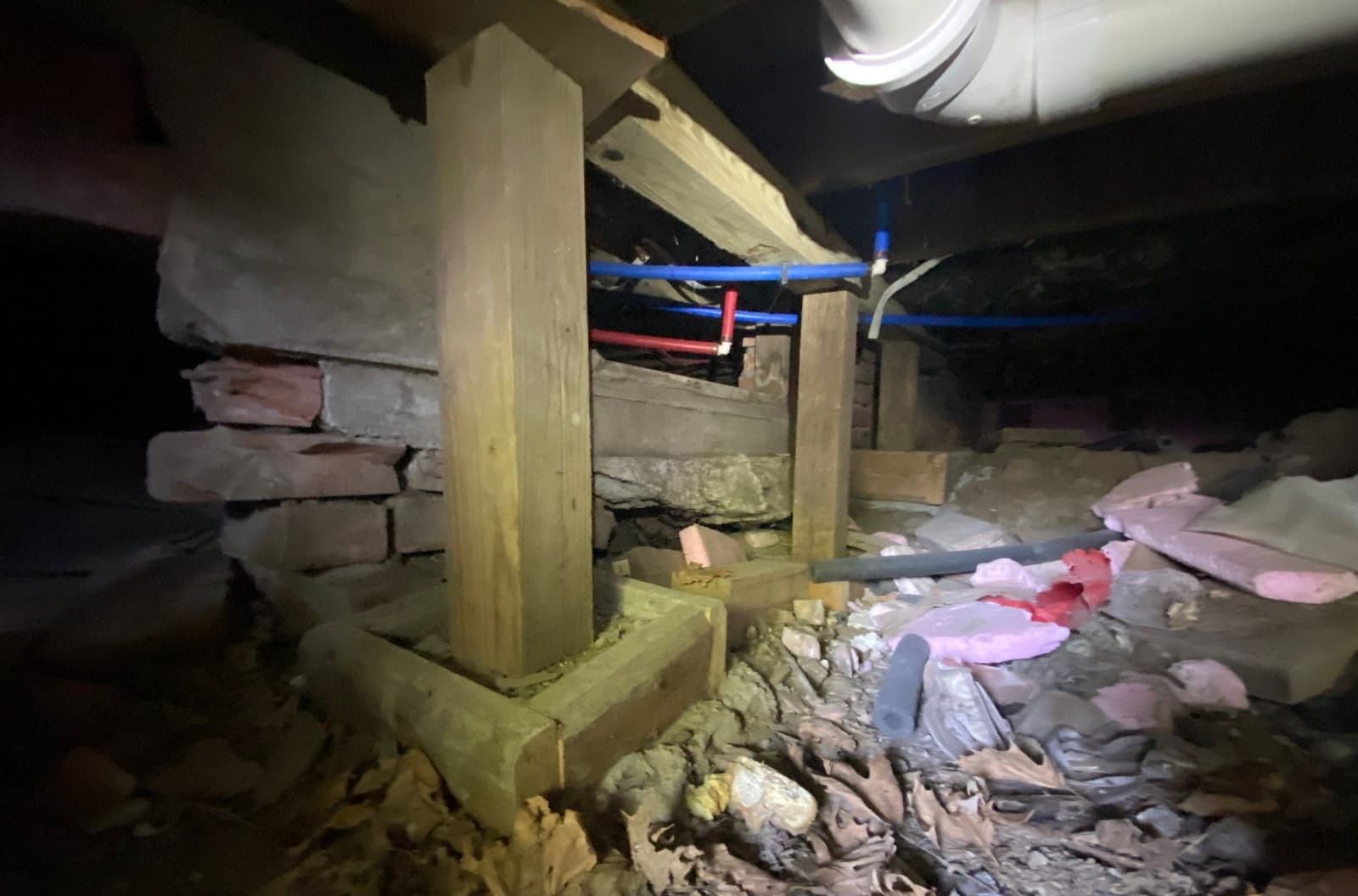Epp Foundation Repair inspecting a crawl space with deteriorating insulation and temporary supports in Macedonia, IA.