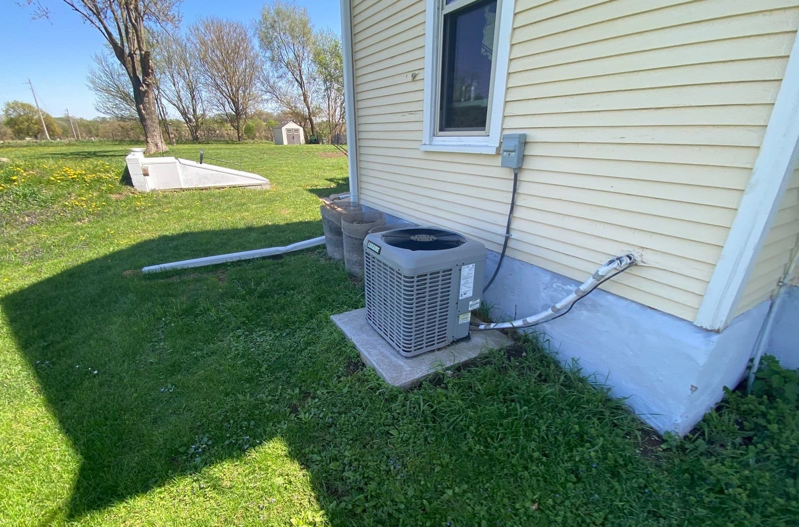 Epp Foundation Repair showcasing a residential exterior with a crawl space access well and foundation drainage in Macedonia, 