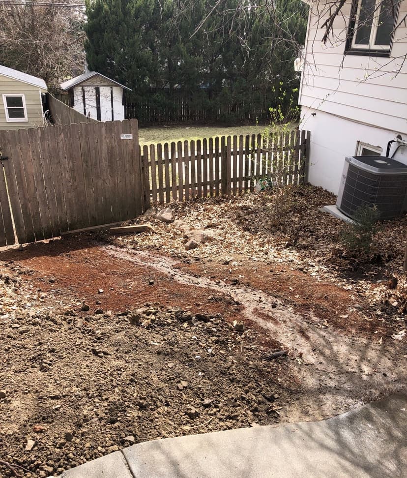 Epp Foundation Repair inspecting water erosion and improper drainage near a residential foundation in Lincoln, Nebraska.
