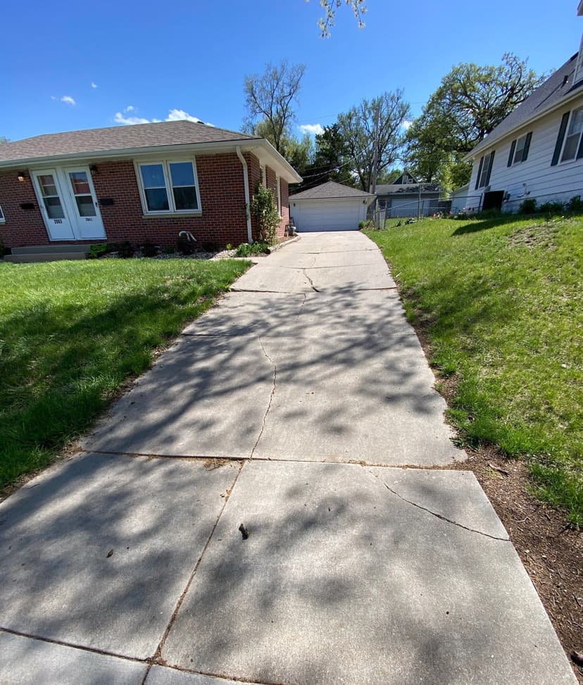 Epp Foundation Repair inspecting cracks in concrete and a cracked driveway at a residential property in Lincoln, NE.