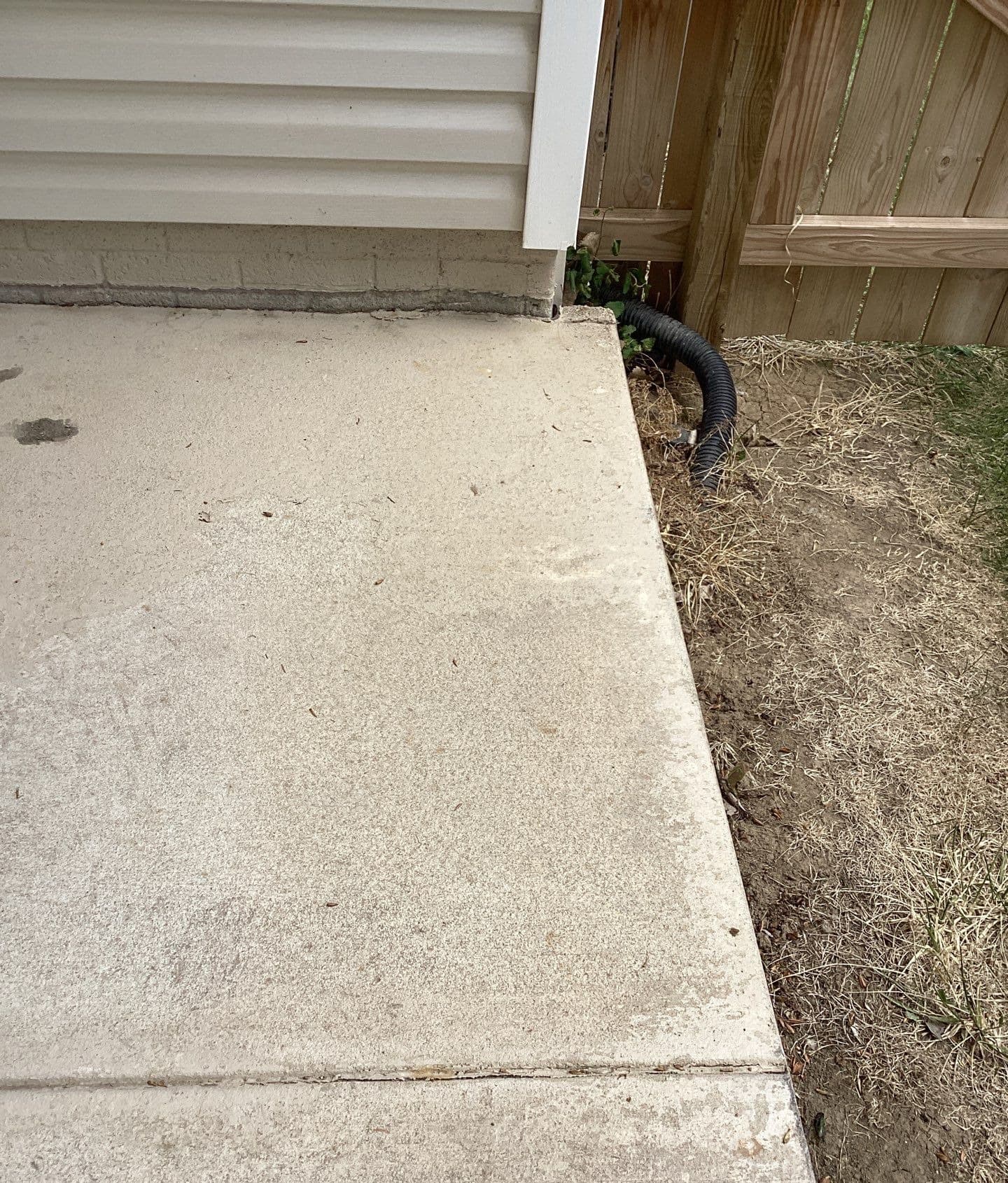 Epp Foundation Repair inspecting cracking expansion joint and drainage system near an exterior concrete slab in Lincoln, nebr