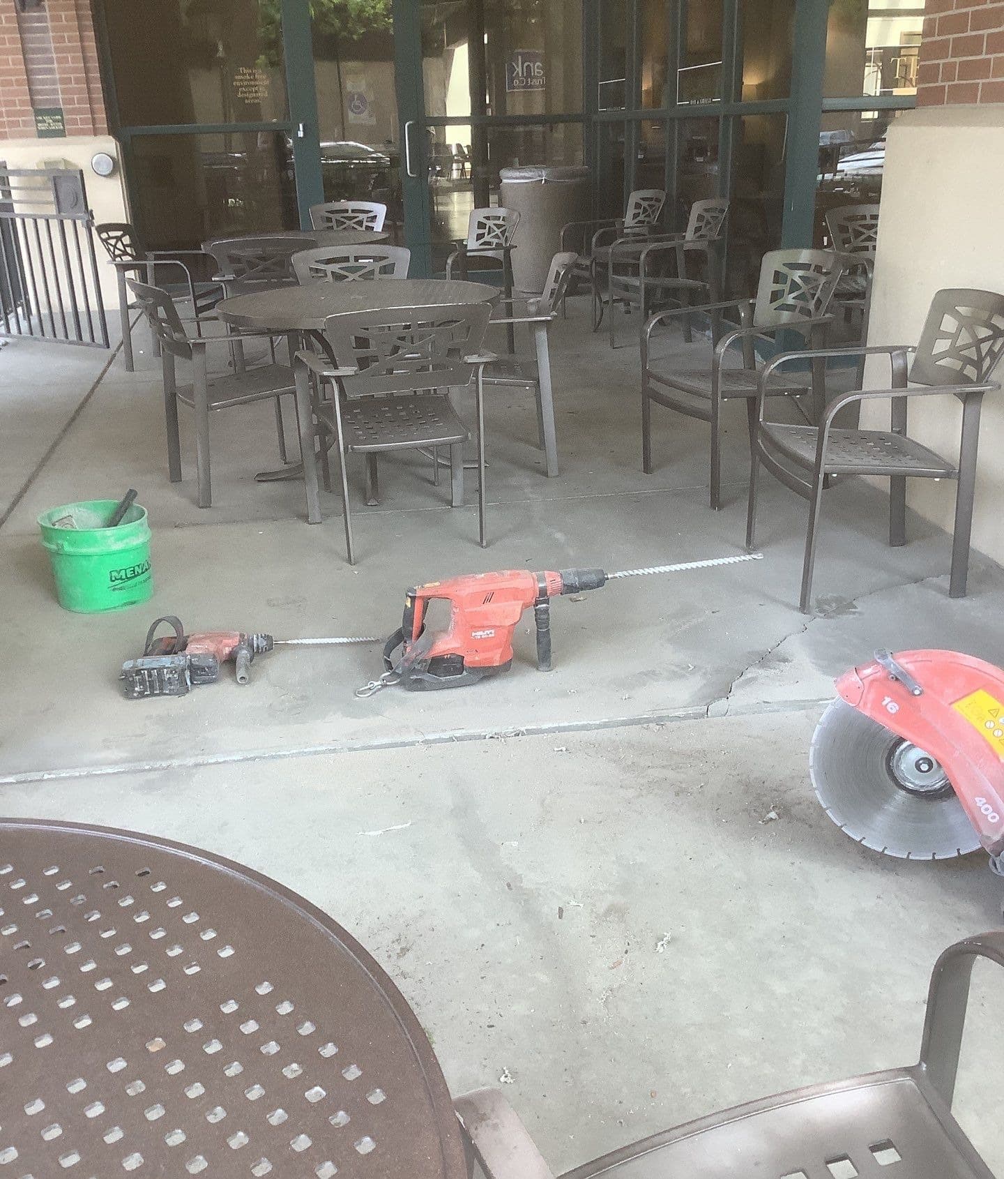 Epp Foundation Repair crew's concrete drilling equipment and cut-off saw next to cracks in concrete at a commercial site