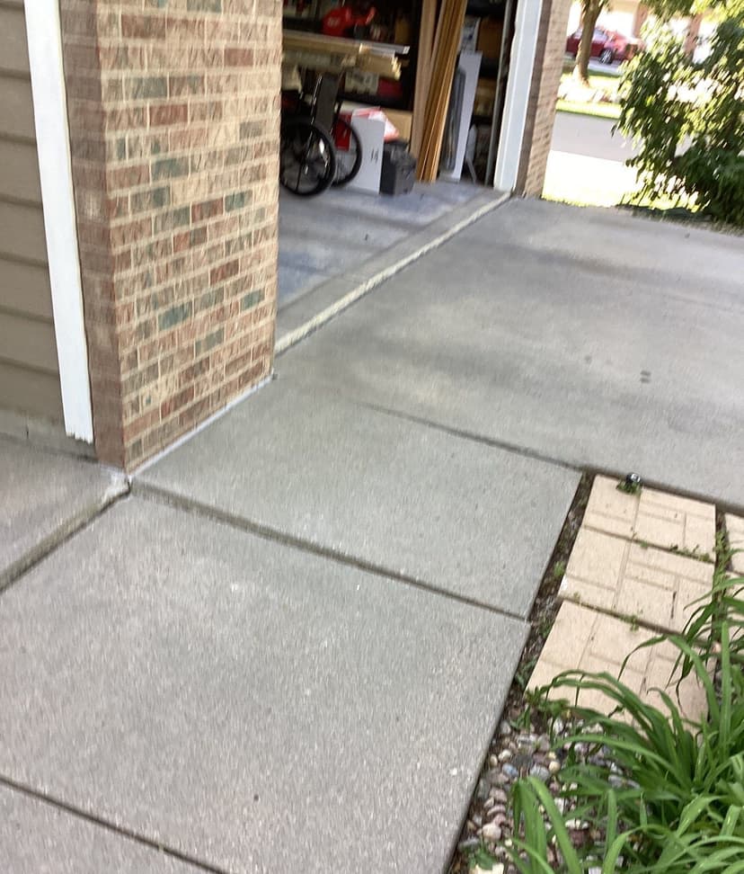 Epp Foundation Repair inspecting uneven concrete sidewalk with cracking expansion joints in Lincoln, NE.