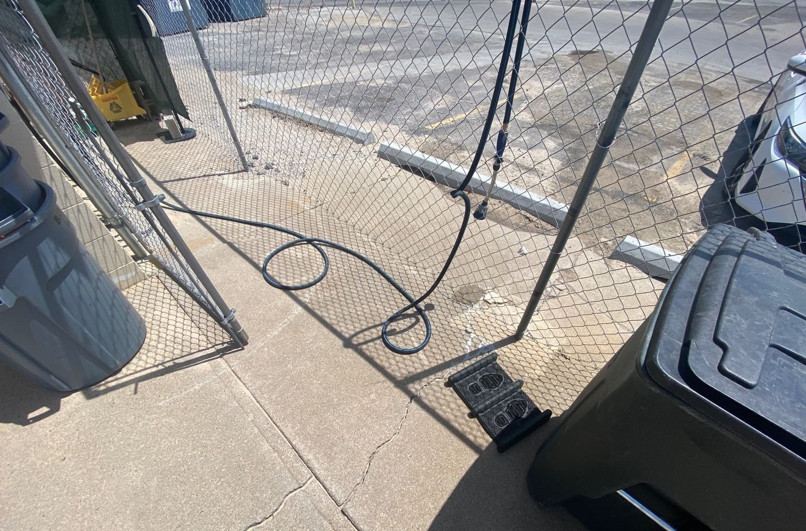 Epp Foundation Repair inspecting cracks in a concrete sidewalk near a chain link fence in Omaha, NE.