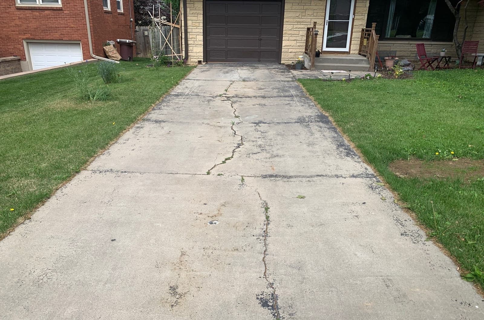 Epp Foundation Repair inspecting a severely cracked and pitted concrete driveway in Lincoln, NE.