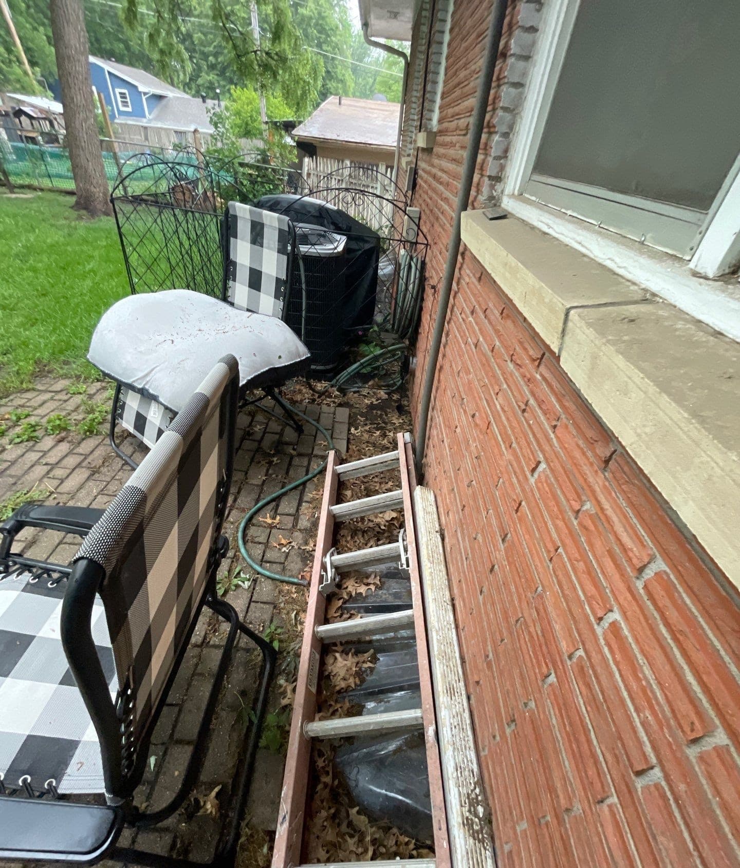 Epp Foundation Repair inspecting the exterior foundation and ground drainage system near a ladder in Lincoln, NE.