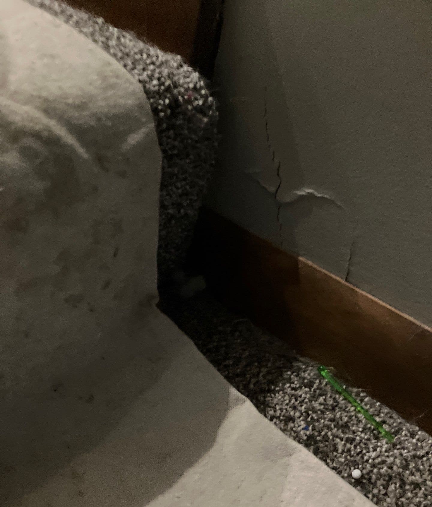 Epp Foundation Repair inspecting severe vertical wall cracks and peeling paint on an interior wall in Lincoln, Nebraska.