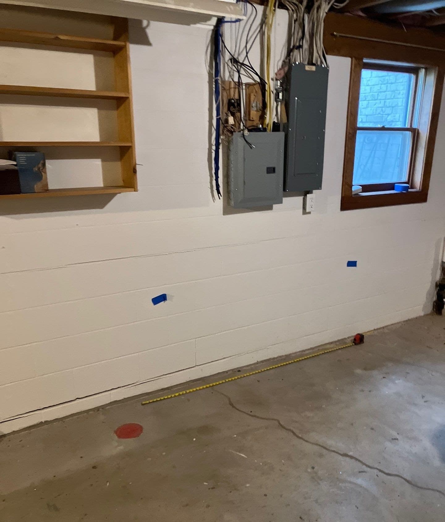 Epp Foundation Repair inspecting a horizontal crack in a block foundation wall and concrete floor in a basement in Lincoln, N