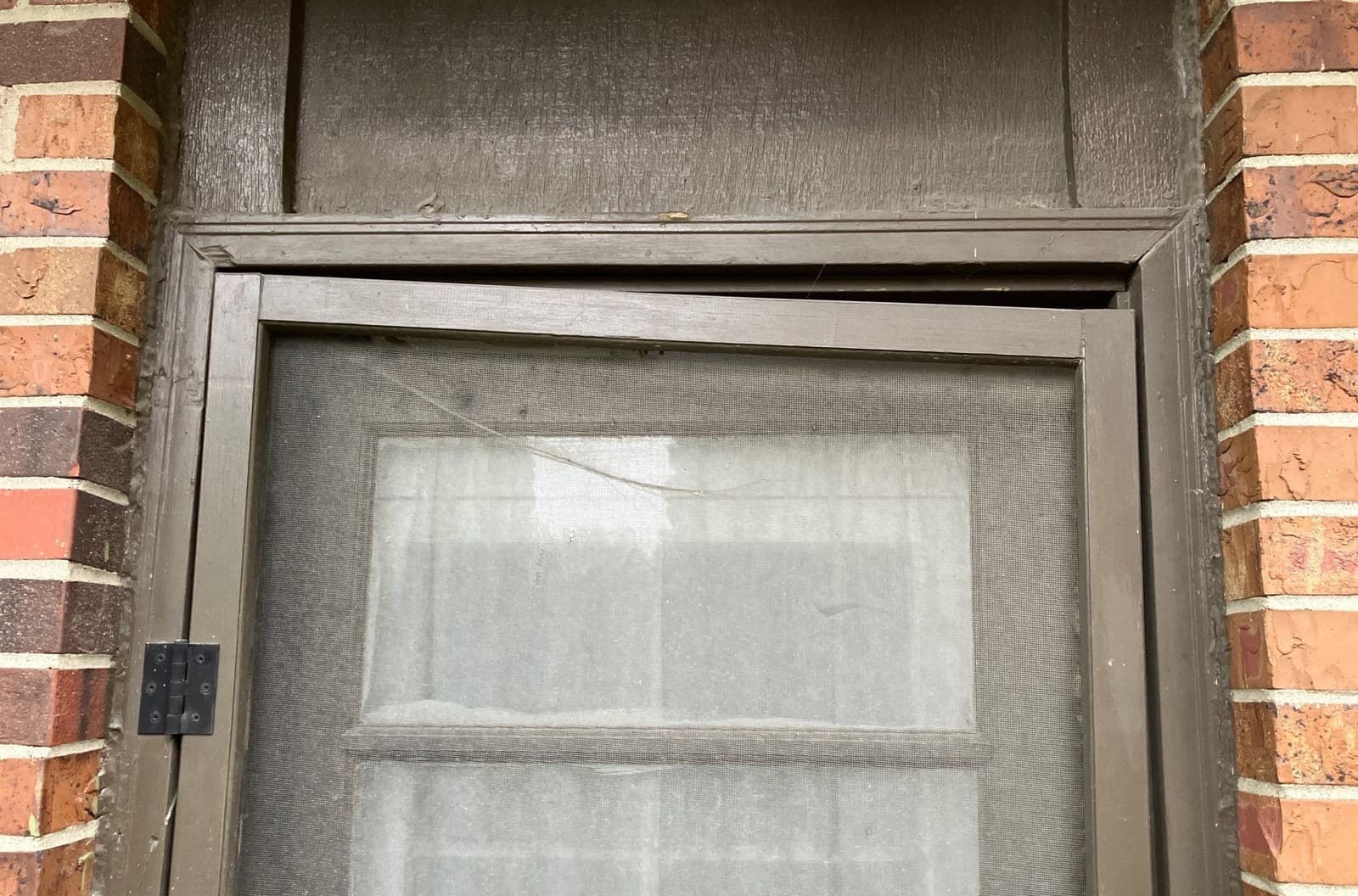 Epp Foundation Repair inspecting a misaligned and warped screen door frame due to potential foundation issues.