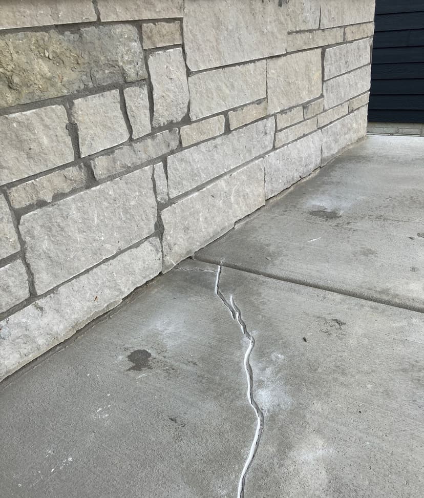 Epp Foundation Repair sealing a cracked concrete slab next to a stone foundation wall with a crack repair solution in Davey, 