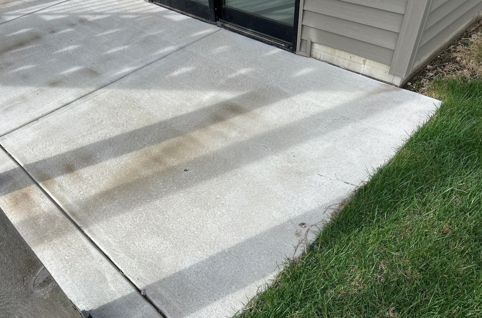 Early warning signs of pitting, flaking, and staining on exterior concrete on a Midwest home