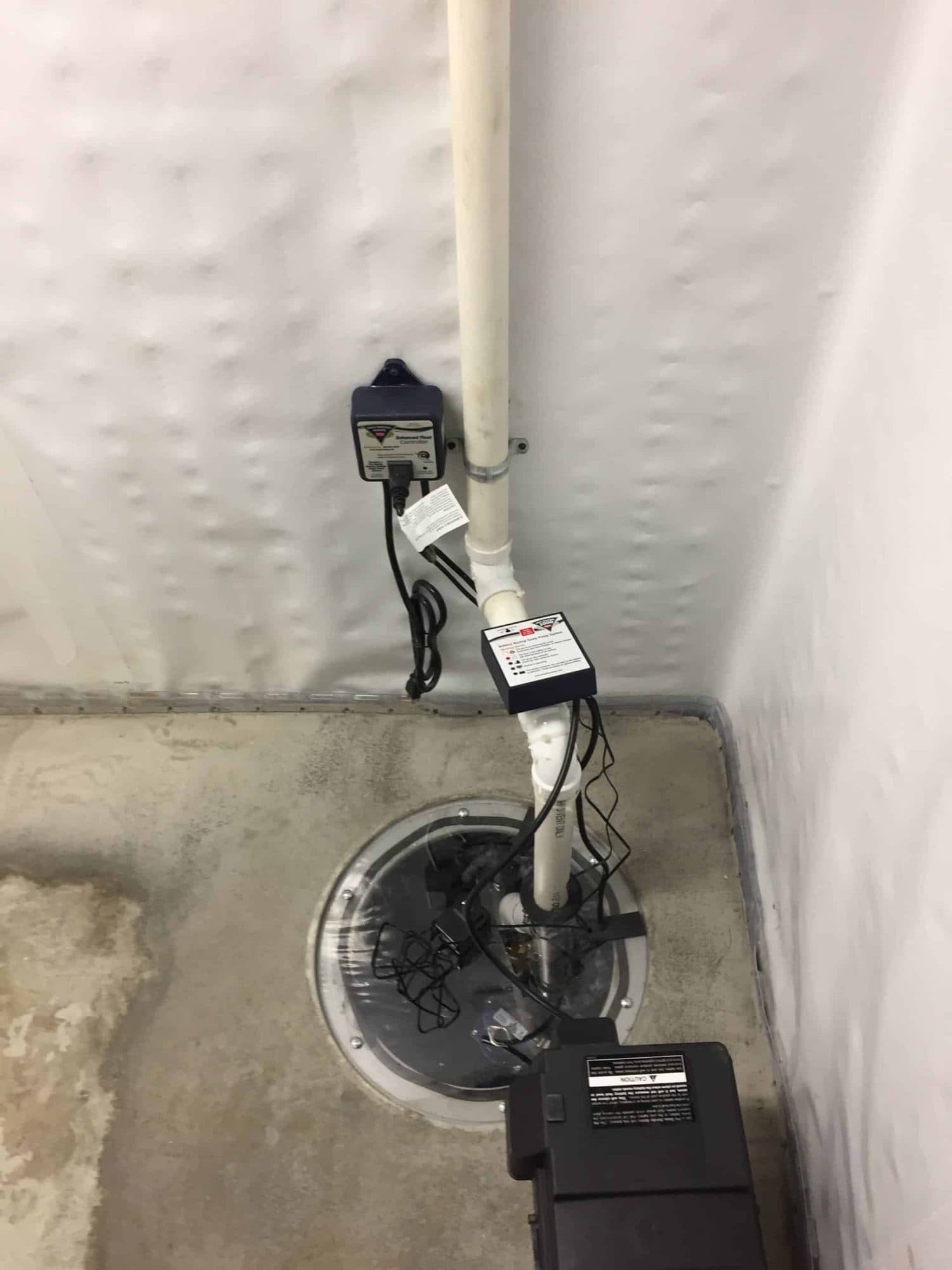 Epp Foundation Repair installing a sump pump with battery backup and a vapor barrier in a basement.