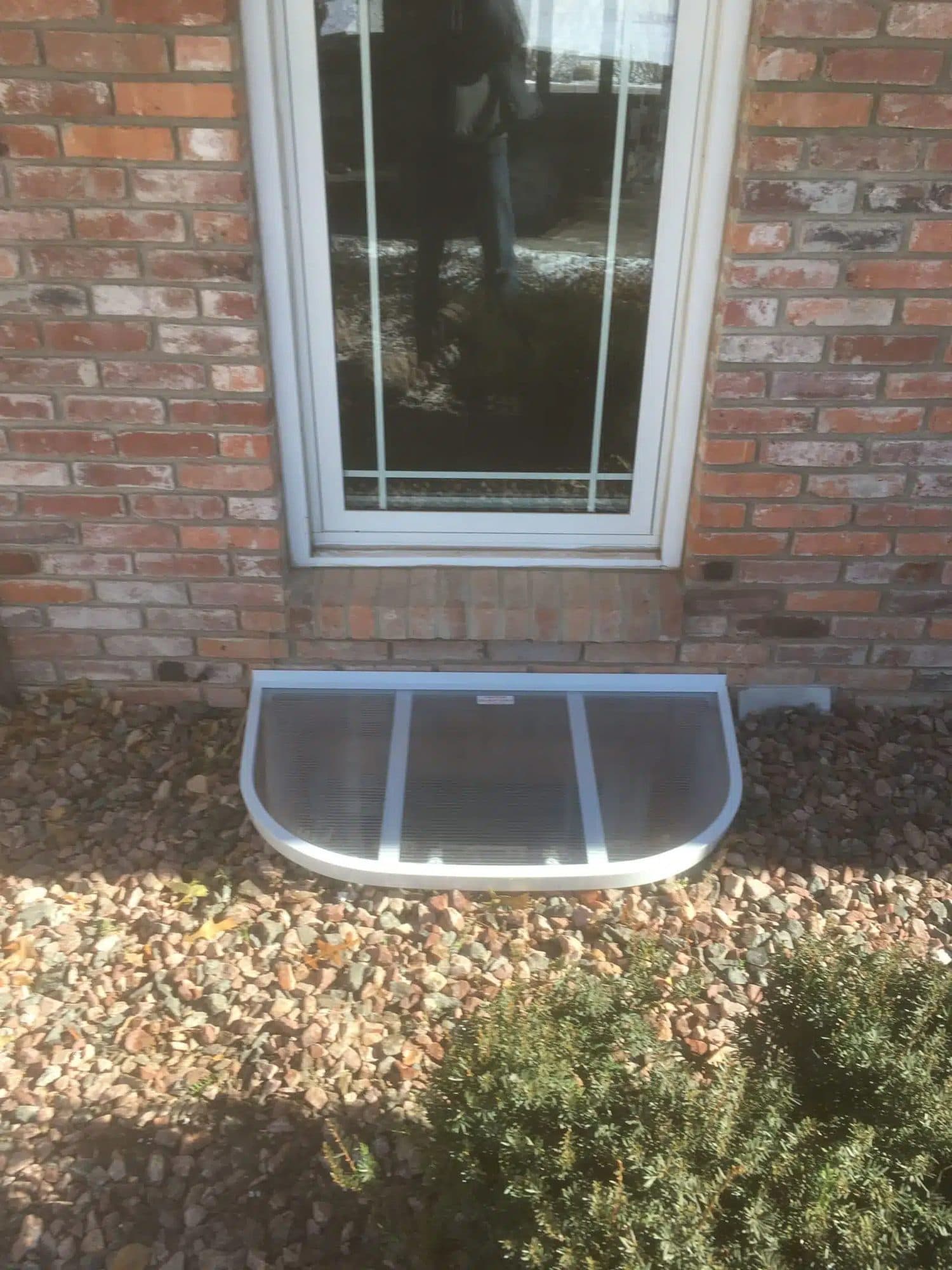 Epp Foundation Repair showcasing a clear plastic window well cover on a brick house.