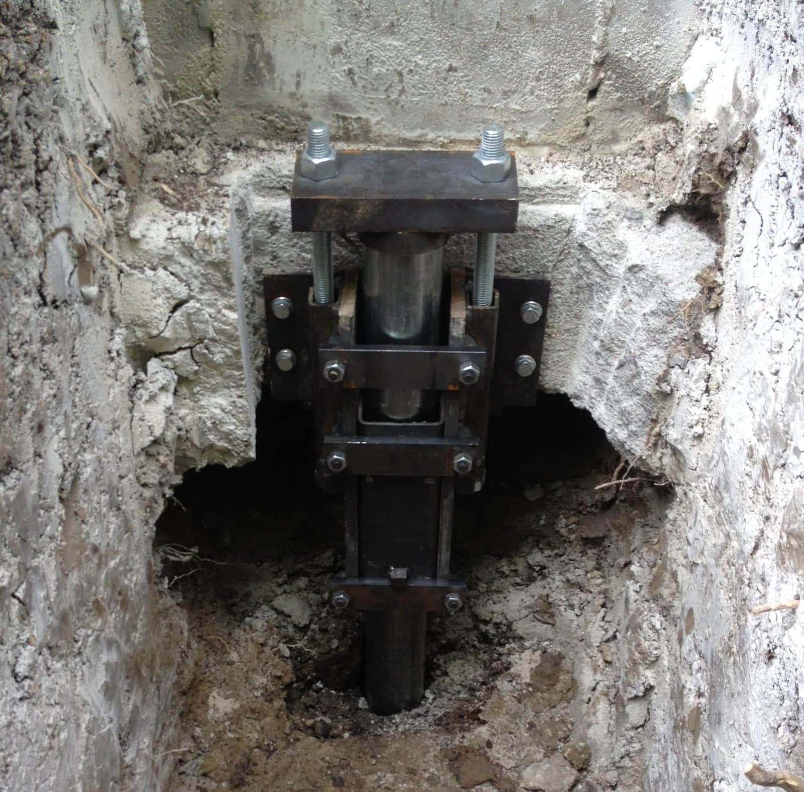 Epp Foundation Repair installing steel push piers with a hydraulic ram against a concrete footing.