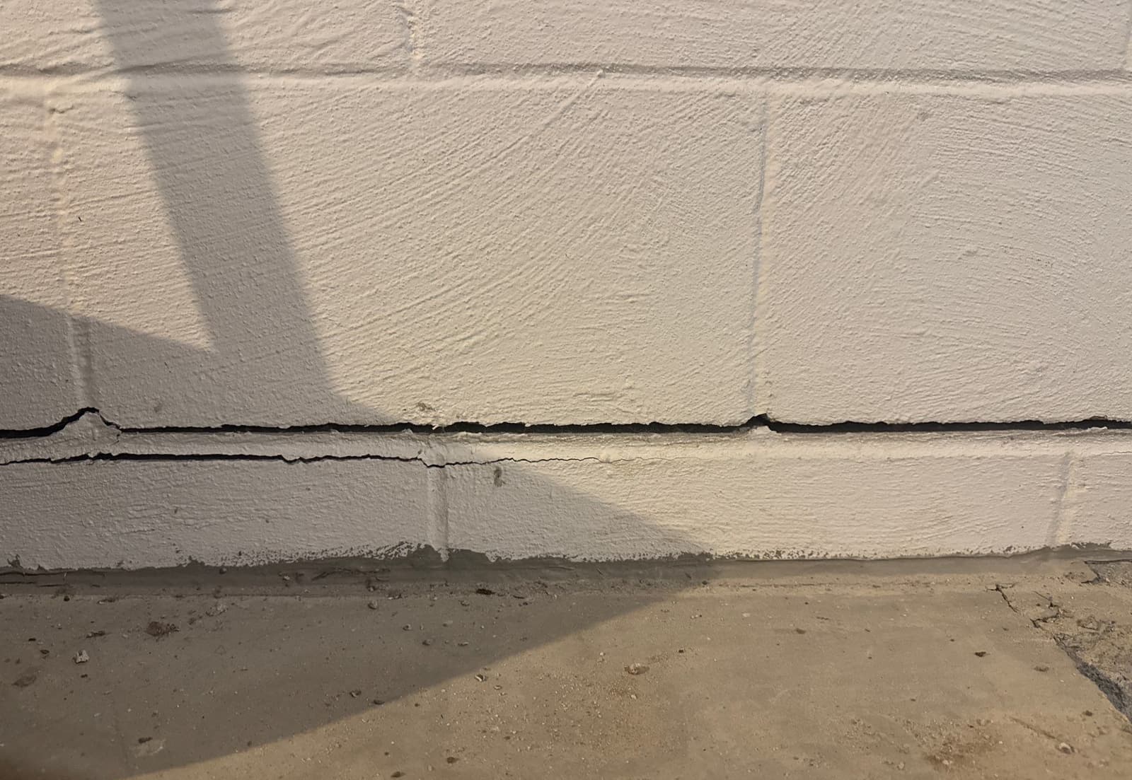 Epp Foundation Repair inspecting a severe horizontal crack in a concrete block basement wall.