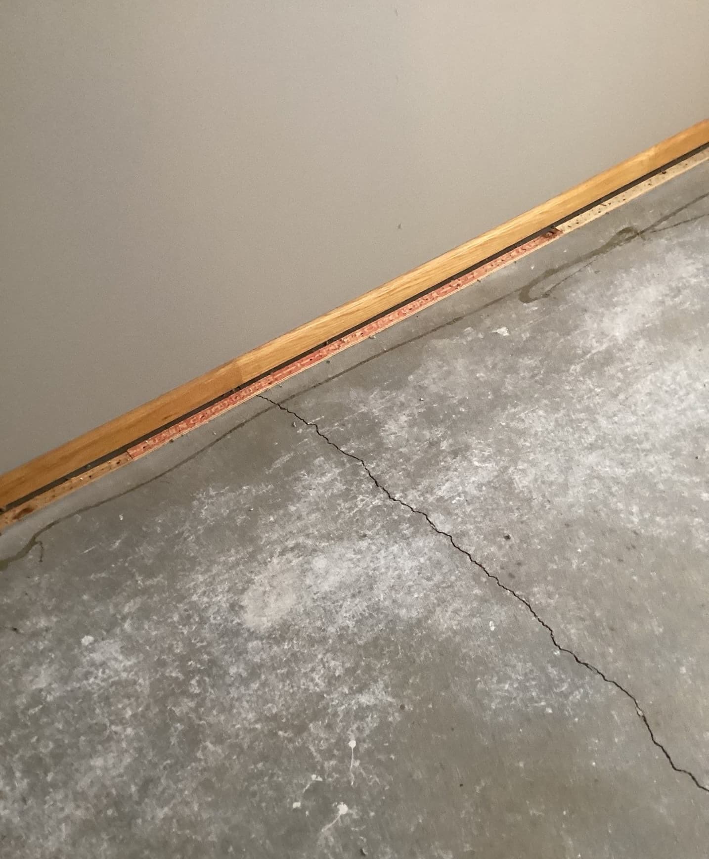 Epp Foundation Repair inspecting a hairline crack in a concrete garage floor.