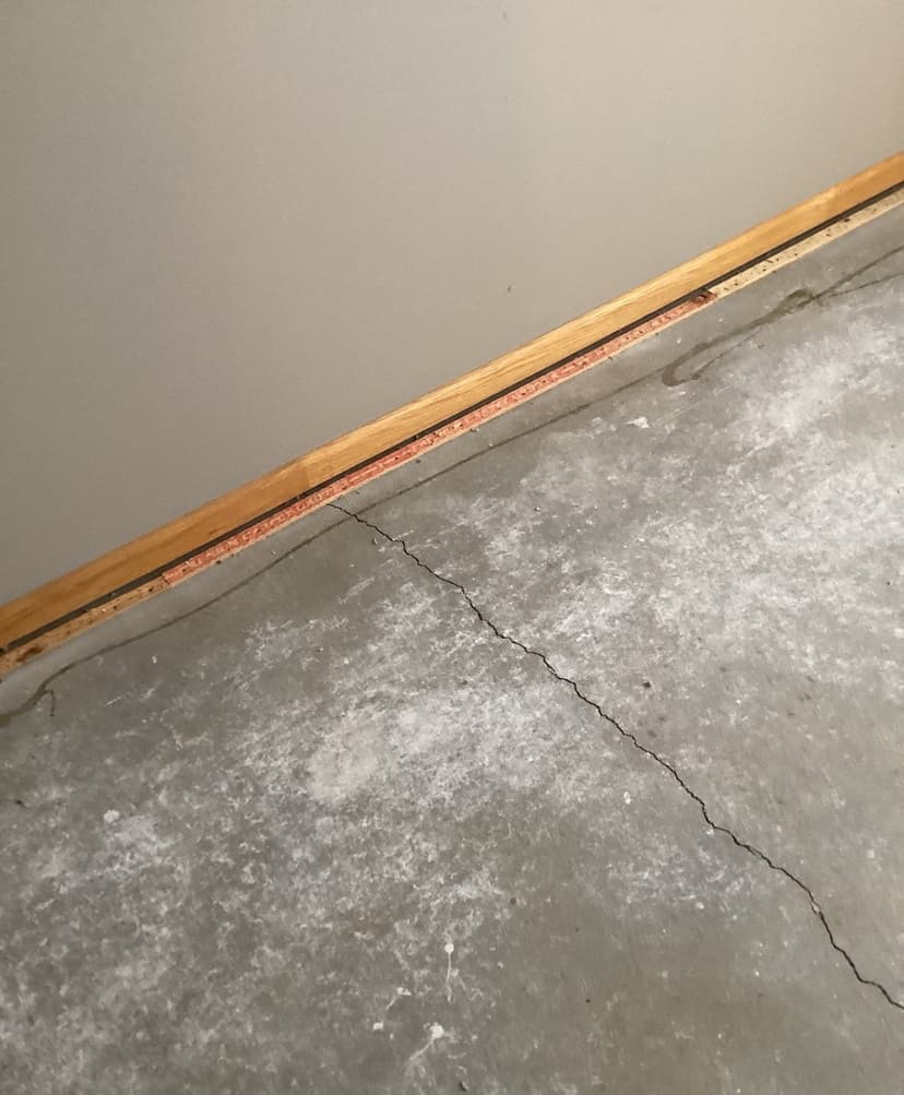 Epp Foundation Repair inspecting a hairline crack in a concrete garage floor.