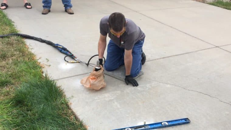 Epp Foundation Repair crew performing polyurethane foam injection to level a commercial driveway slab.