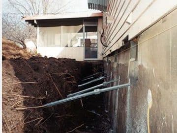 Epp Foundation Repair installing helical tieback anchors to stabilize a residential foundation wall.