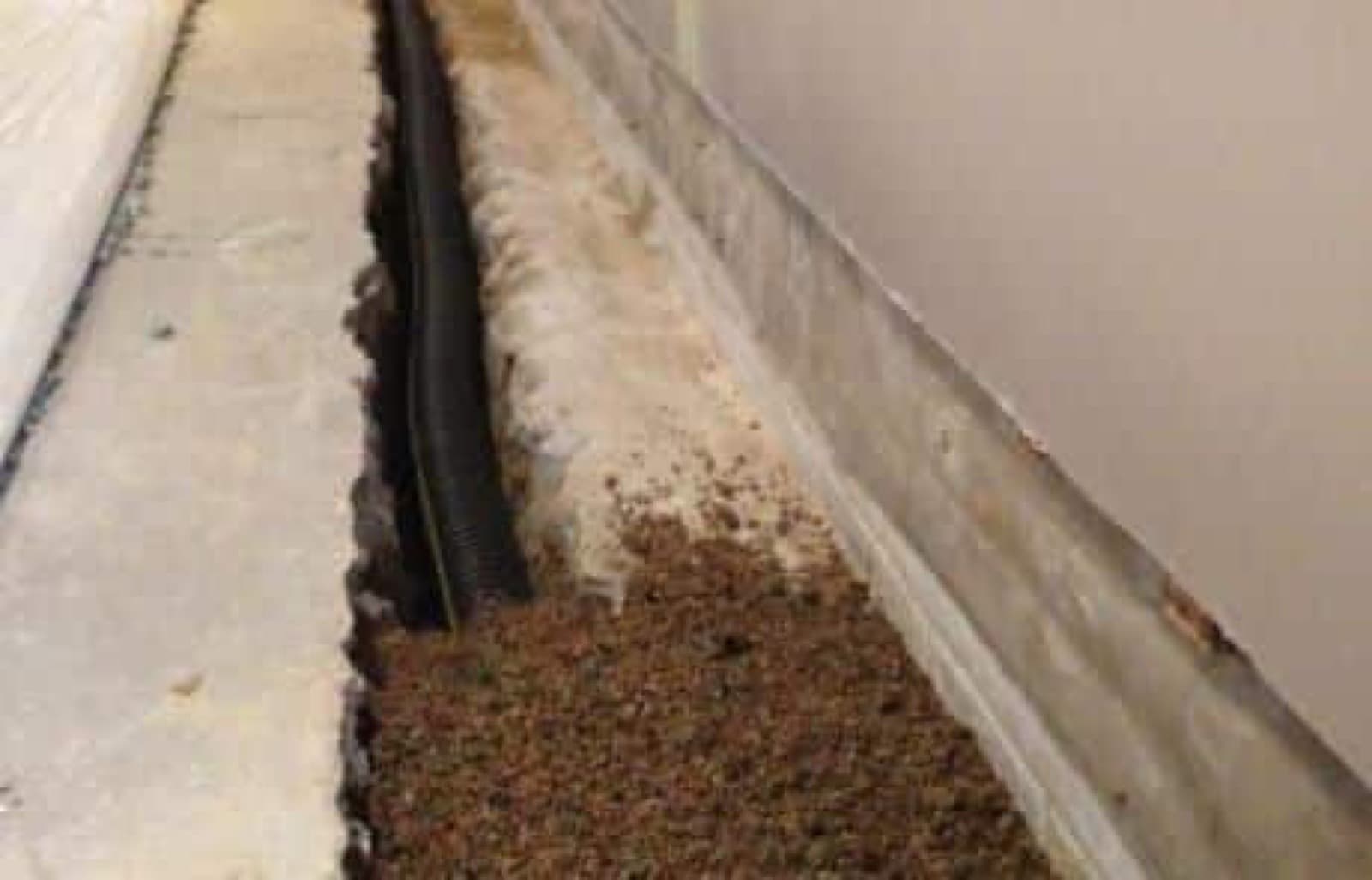 Interior drain tile system installed along a basement floor