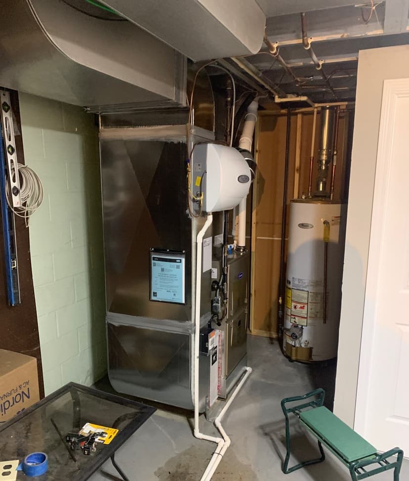 Epp Foundation Repair inspecting water on basement floor from HVAC drainage pipe in Omaha, Nebraska.